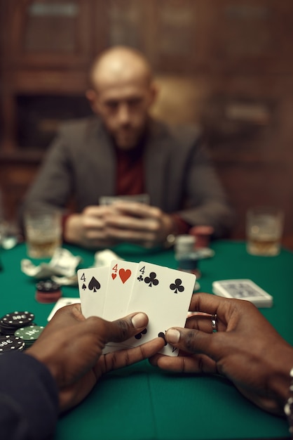 Mannelijke handen met kaarten, pokerspeler in pak