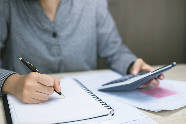 Mannelijke handen met pen die op notitieboekje schrijven