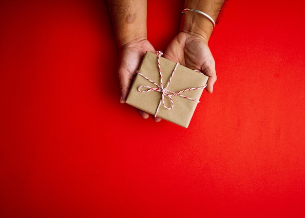 Mannelijke handen met rode geschenkdoos