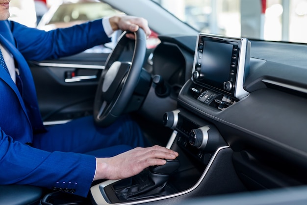 Mannelijke handen op stuur, auto-interieur