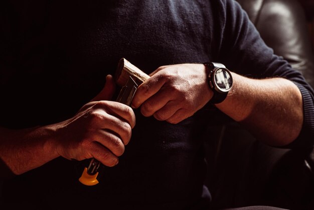 Foto mannelijke handen snijden hout met een mes