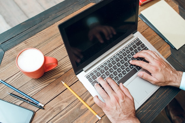 Mannelijke handen typen op laptop toetsenbord