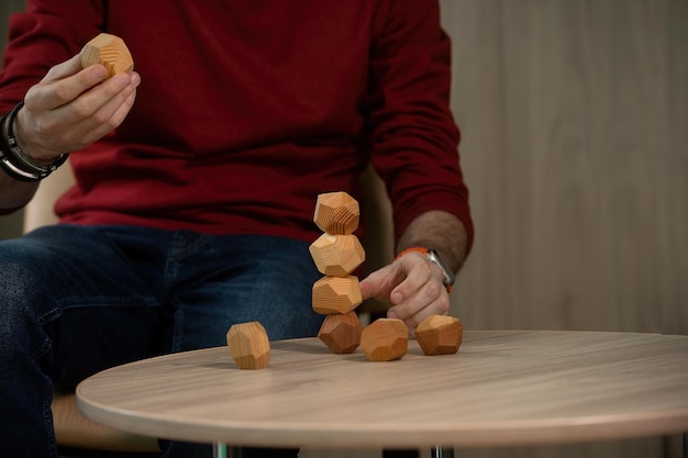 Mannelijke handen verzamelen figuren van houten veelvlakken eco-spellen voor volwassenen en kinderen