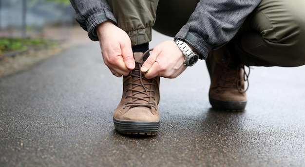 Foto mannelijke handsnoeren op bruine schoenen close-up