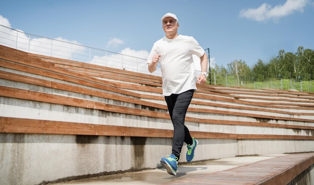 Mannelijke hardloper gepensioneerde sport doet een fitnesstraining in het park