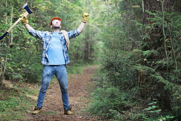 Mannelijke houthakker in het bos. Een professionele houthakker inspecteert bomen op kap.