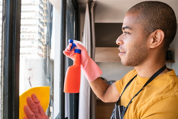 Mannelijke huishoudster glazen raam thuis schoonmaken