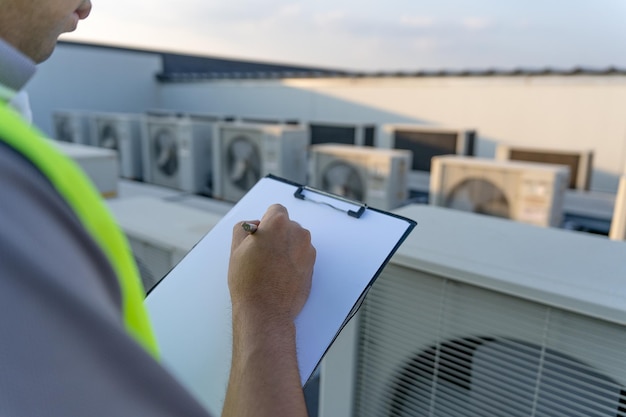 Mannelijke industriële ingenieurs controleren en inspecteren de aanpassing van de installatie nieuwe compressor airconditioner volgens de energiebesparende inspecteur van het bedrijf werkt in de fabriek