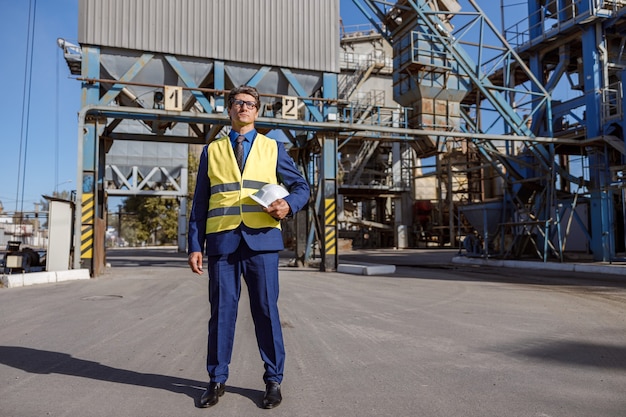 Mannelijke ingenieur die zich op asfaltweg bevindt in fabriek