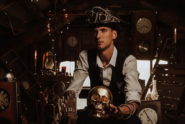 Foto mannelijke ingenieur in een steampunk-pak in een hoge hoed met een bril en mechanismen