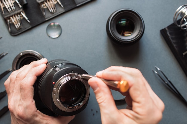 Mannelijke ingenieur lens van fotocamera herstellen