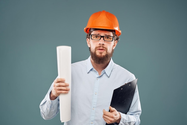 Mannelijke ingenieur professionele oranje bouwvakker veiligheid bouw blauwdrukken in handen