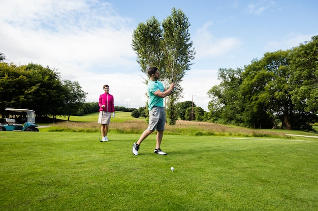 Mannelijke instructeur bijwonende vrouw in het leren van golf