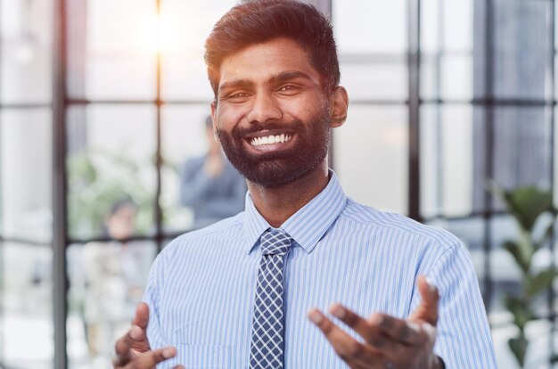 mannelijke investeerdersbaard die naar de camera kijkt en glimlacht in een modern kantoor