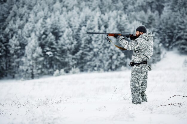 Mannelijke jager in camouflage op zoek naar zijn doelwit of prooi Winters tafereel