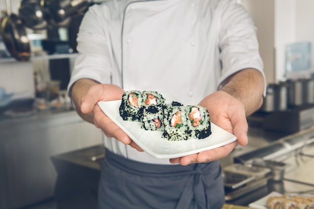 Mannelijke Japanse restaurantchef die in de gekookte keukenschotel kookt cooking