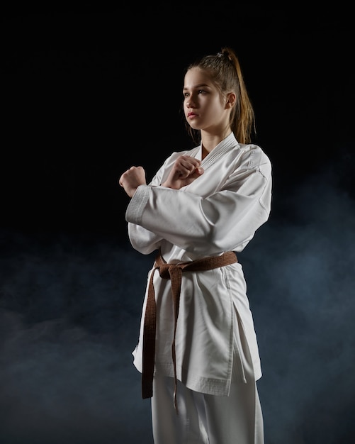 Mannelijke karatevechter in witte kimono, welkom teken. Karateka op training, vechtsporten, training voor vechtwedstrijden