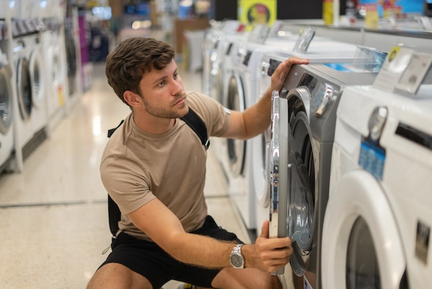 Mannelijke klant die wasmachine inspecteert