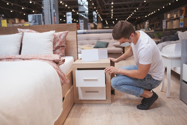 Mannelijke klant slaapkamermeubilair bij winkel te onderzoeken