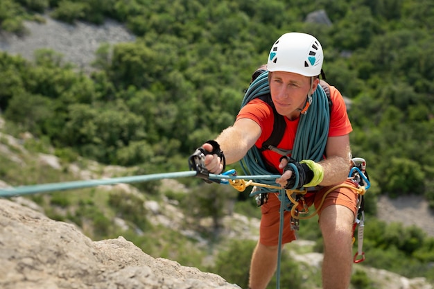 Mannelijke klimmer beklimt de berg aan een veiligheidstouw