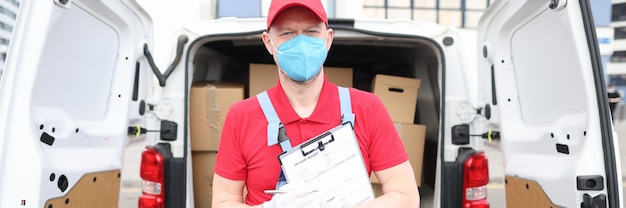 Mannelijke koerier met beschermend medisch masker bezorgt pakketten