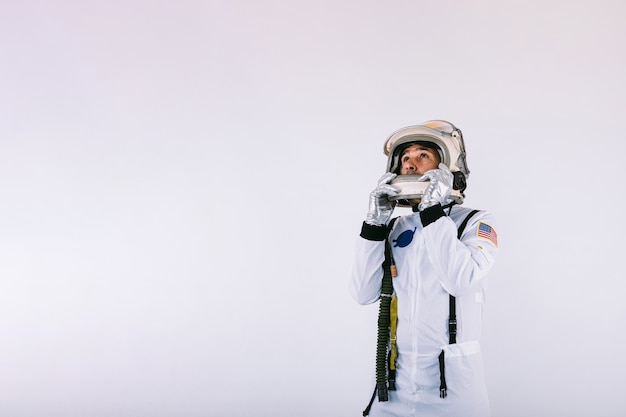 Mannelijke kosmonaut in ruimtepak en helm met helm met handen op witte achtergrond