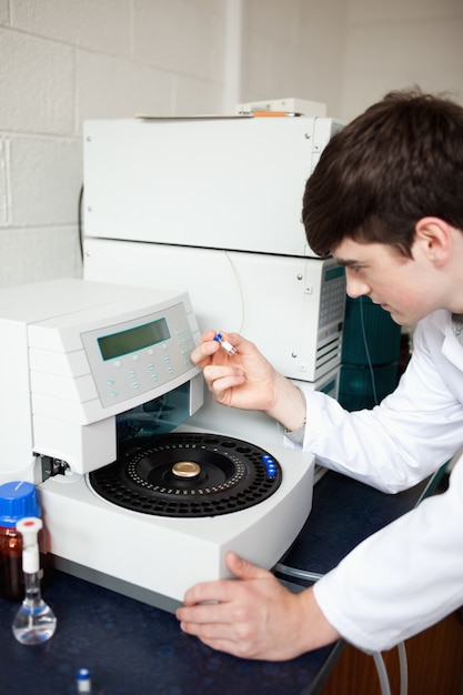 Mannelijke laboratoriummedewerker die een centrifuge gebruikt