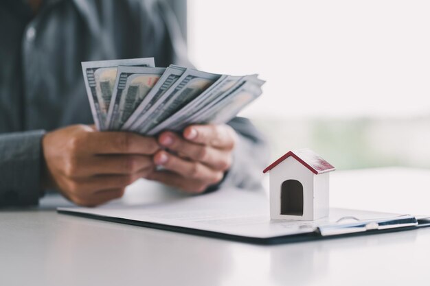 Mannelijke makelaar telt geld na een succesvolle deal voor het kopen van een huis