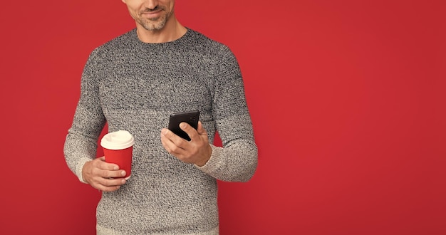 Mannelijke mannequin houdt kop en smartphone 's ochtends koffie concept van communicatie