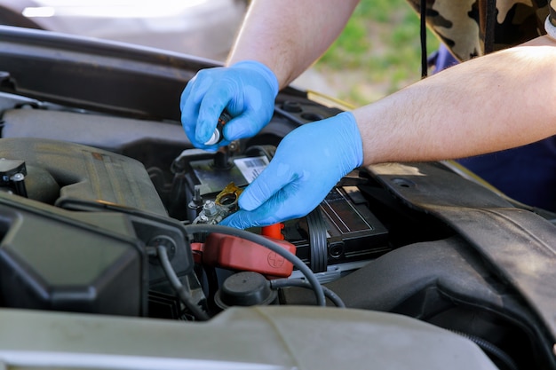 Mannelijke mechanische vervangende autobatterij in workshop