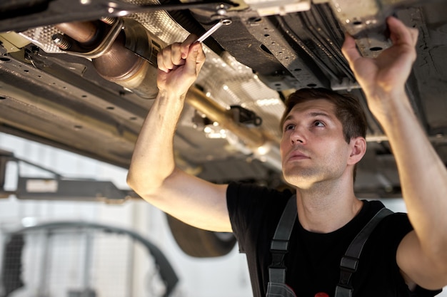 Mannelijke monteur werkt aan een voertuig in een autoservice