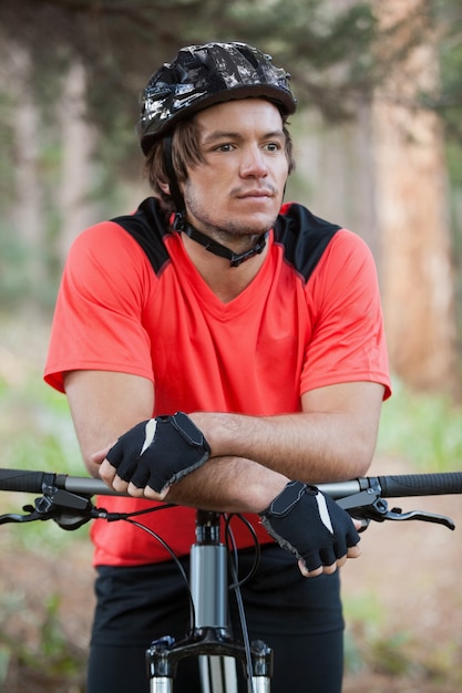 Mannelijke mountainbiker met fiets in het bos