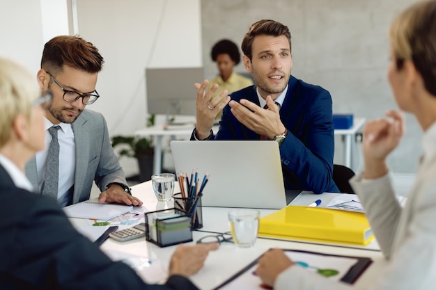 Mannelijke ondernemer die met zijn collega's communiceert tijdens een zakelijke bijeenkomst