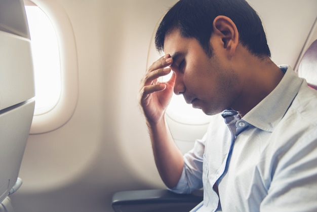 Mannelijke passagier met luchtziekte in het vliegtuig