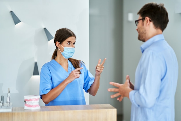 mannelijke patiënt die voor tandbezoek in kliniek betaalt