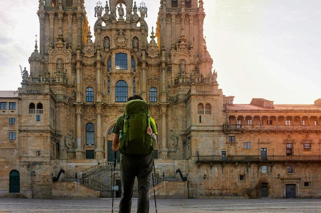 Mannelijke pelgrim met een rugzak op het hoofdplein van Santiago de Compostela