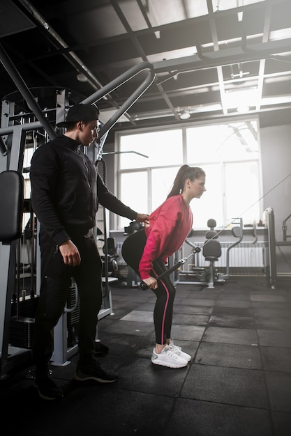 mannelijke personal trainer die zijn vrouwelijke cliënt coacht in de sportschool