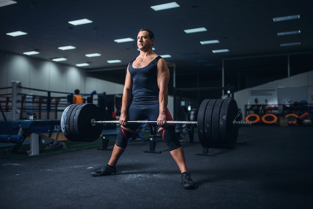 Mannelijke powerlifter voorbereiding deadlift barbell in sportschool