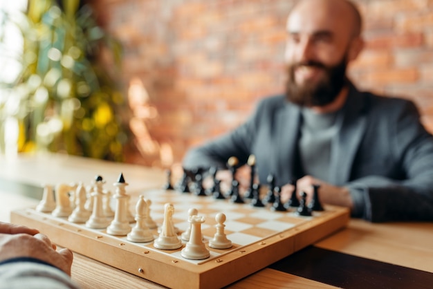 Mannelijke schakers beginnen te spelen, focus aan boord met figuren.