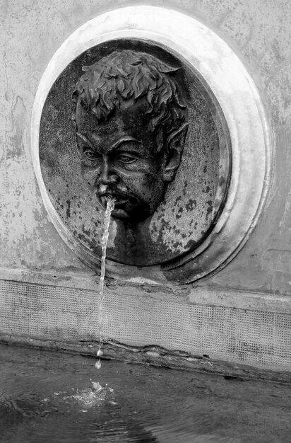 Mannelijke sculptuur die water bij een fontein giet