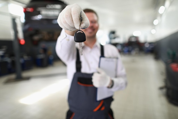 Mannelijke servicemedewerker geeft sleutels van vaste auto aan eigenaar