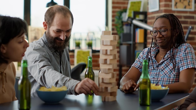 Mannelijke speler verliest bij samenlevingsspel met houten toren op tafel