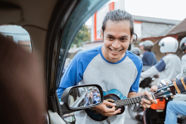 mannelijke straatmuzikant smeekt om geld bij stoplicht