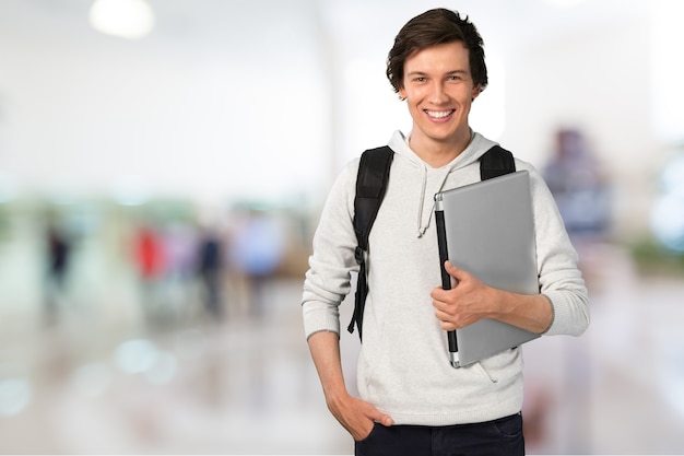 Mannelijke student met laptop op achtergrond