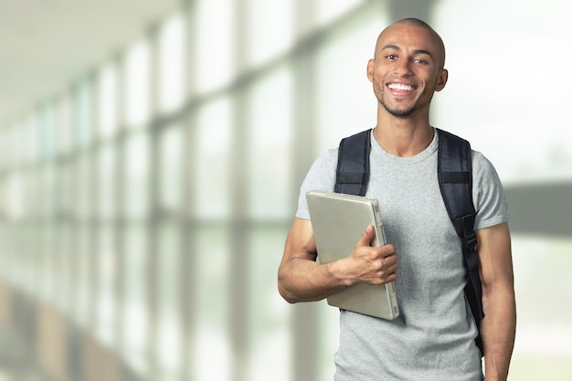 Mannelijke student met rugzak op achtergrond