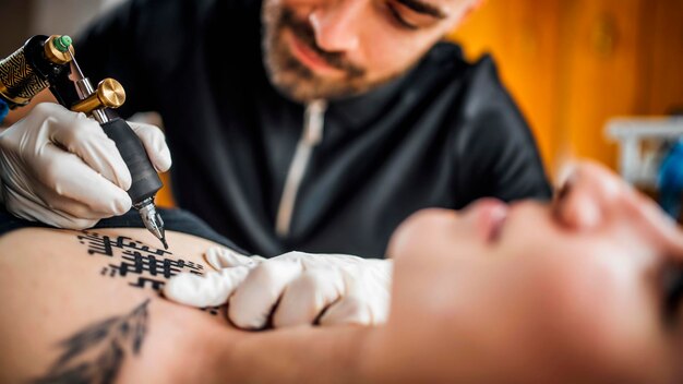 Mannelijke tatoeëerder tatoeëren jonge vrouw in tattoo studio