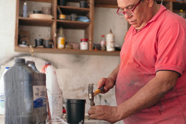 Mannelijke timmerman knutselen met hout in zijn winkel