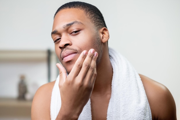 Mannelijke verzorging huidverzorging Afrikaanse man gezicht aan te raken