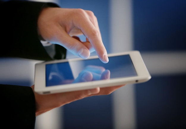 Mannelijke vinger wat betreft het tabletscherm op onscherpe achtergrond