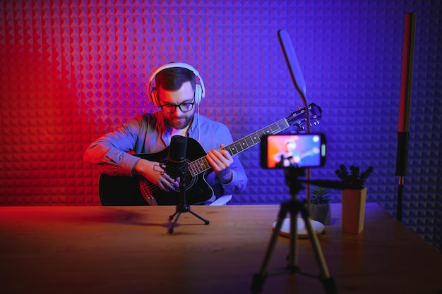 Mannelijke vlogger die muziekgerelateerde uitzendingen opneemt in de studio